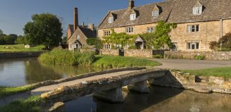 Traditional Cotswold stone cottages and stone footbridge in the Cotswolds village of Lower Slaughter. Credit: Visit Britain